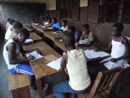 Jeunes en classe autour de pupitres